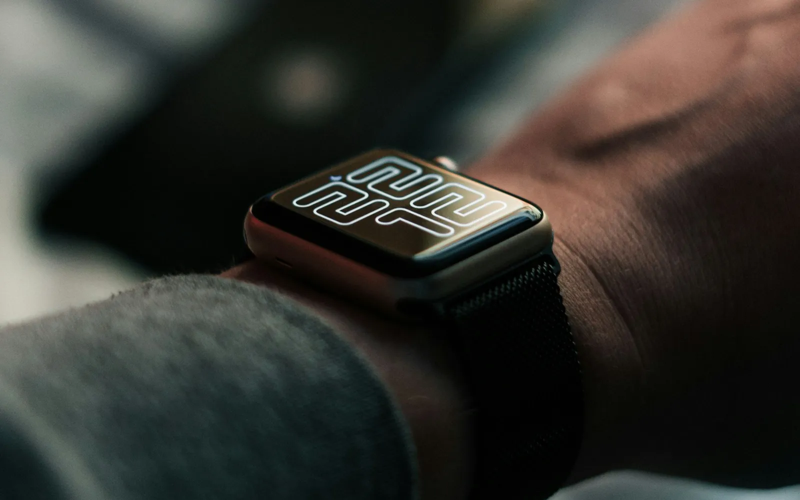 A smartwatch on a wrist in low evening light, its screen showing 22:12