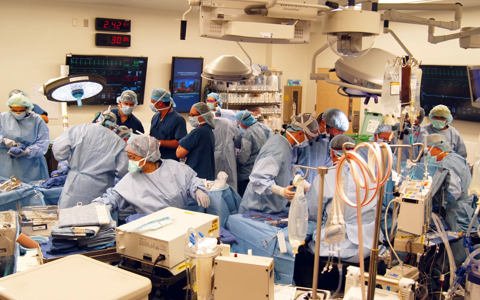 A surgical team in gowns, masks and caps works around an operating table during a transplant at Johns Hopkins Hospital